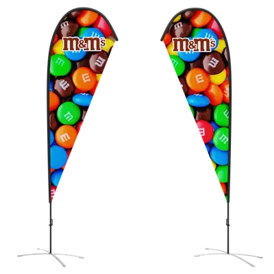 Two vertical teardrop-shaped banners with a colorful M&M's design flank a set of steps, likely advertising the candy at an event or store display.