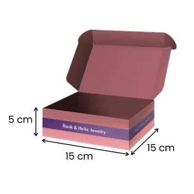 15 x 15 x 5 cm A custom-branded open jewellery box featuring a patterned design and a chess rook icon, labelled 'Rook & Helix jewellery', positioned against a shadowed backdrop.