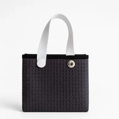 A close-up of an orange towel with a grey hanging loop and button closure, likely a feature of custom beach towels or personalised hand towels.